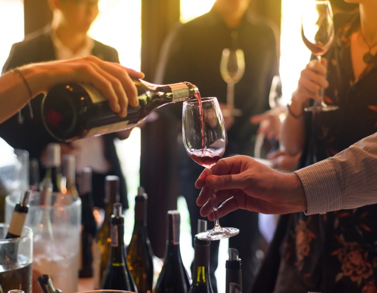 Wine being poured into a held glass