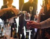 Wine being poured into a held glass view 1