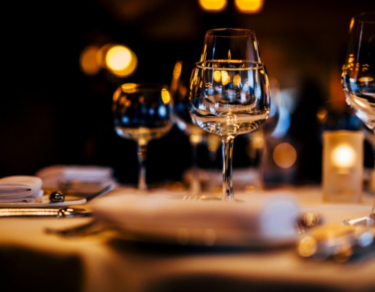 Dark lit laid table with crockery and glassware