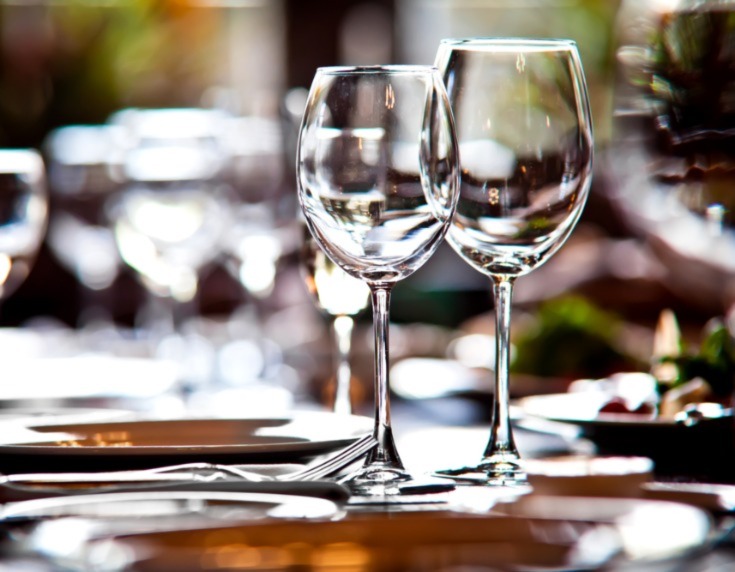 Wine glasses in foreground on dining table