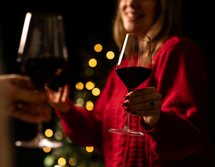 Lady in red holding glass of red wine