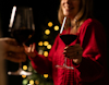Lady in red holding glass of red wine