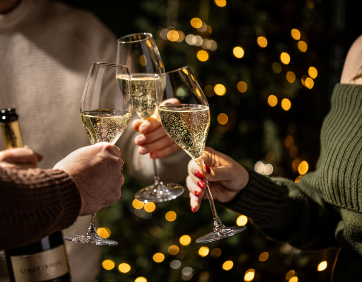Three flutes of sparkling wine being raised in a toast
