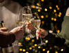 Three flutes of sparkling wine being raised in a toast